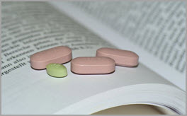 Tabletten auf offenem Buch