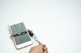 Digital Detox (Symbolbild zeigt ein mit Kette und Schloss »versperrtes« Smartphone)